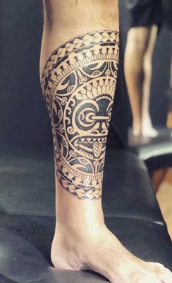  Tatouage maori, polynésien du bas de la jambe avec le tiki en son centre